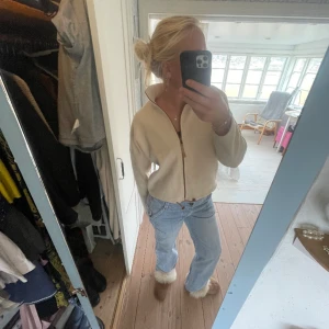 Kräm vit Teddy tröja  - Jötte mysig och fin flis! Anvönd men inget som märks. Brun dragkedja och bruna resor nedtill som går att spänna åt men jag gillar att ha de ospända