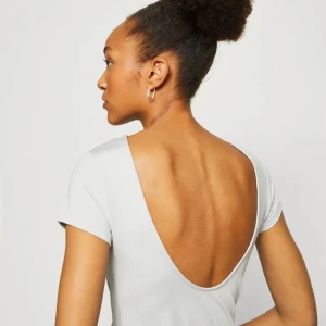 Topp med öppen rygg - Helt ny t-shirt med öppen rygg från Weekday. Superfin och aldrig använd!!Storlek Xs men väldigt stretchig modell💖💖 Den är vit/beige, som på första bilden!