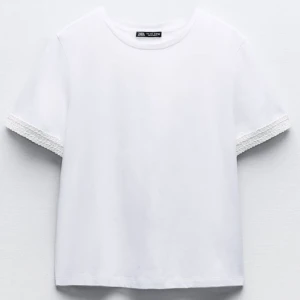 Vit T-shirt med detalj - Andvänd en gång och säljer pågrund av att jag tycker den är lite för basic