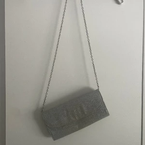 Kuvertväska - Säljer min silverglittriga kuvertväska Använd några gånger  Någon sminkfläck på den