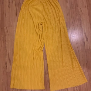 Gula fladdriga byxor från KappAhl - Använda en gång. Storlek 170. 