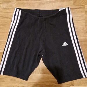 Adidas cykelbyxor - Cykelbyxor från adidas. Sitter bra men tyvärr har en del av sömmen gått sönder på framsidan vid resåren, se bild. Perfekt för träning eller en dag på stan.