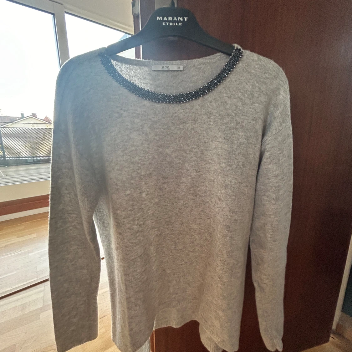 Grå stickad tröja med stenar 