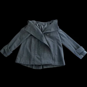 Kort grå kappa från Zara st L - Säljer en jätte söt kort kappa från Zara med huva baktill. Storlek L men känns mer som en M… Den är endast provad och är därför i nyskick  Pris kan diskuteras 