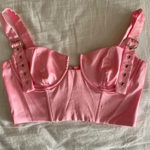 Korsett topp från Oh Polly!  - Säljer en rosa topp från Ohpolly i strl 34, kan användas som 36 med!   Säljer pga att den ej kommer till användning samt att den ej passar längre🤍  Otroooligt snygg till sommaren!! 😍 