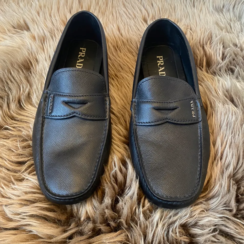 Prada Saffiano Leather  Upper with metal lettering logo applied to  Upper: Saffiano leather the leather saddle Removable insole, Rubber block sole without box  made in Italy. Skor.
