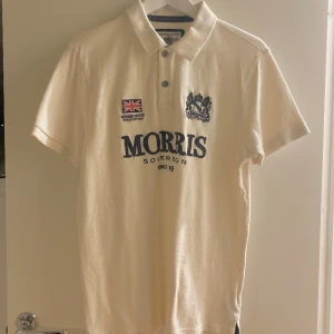 Morris Pikétröja  - Vintage Morris tröja i super bra skick utan defekter! Har 2 knappar. Ribbstickad vid krage och ärmar, perfekt nu under sommaren! Liten i storleken så mer som en M