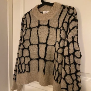 STICKAD TRÖJA - Beige/svart mönster stickad tröja. Fin passform och mönster. Mysig och skön. Köpt för 300kr från objekt, säljer nu för 150kr.