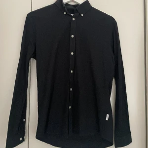 Skjorta från märket Lindbergh - Svart skjorta i slim fit modell i bra skick! 