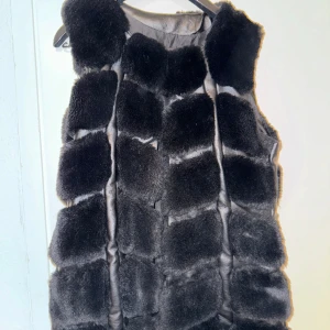 Väst i fuskpäls (ser äkta ut) - Fluffig väst i fuskpäls, står ingen strl men passar mig som är s/m.