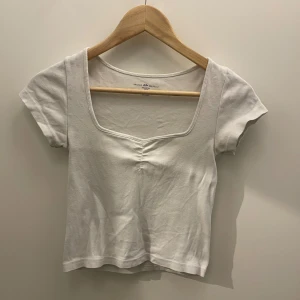 Brandy Melville Mable topp - Vit croppad tshirt med fin halsringning. I fint skick, säljes eftersom den inte kommer tillräckligt till användning.