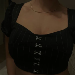Svart crop top med spännen  - Säljer denna fina topp från BOOHOO! 