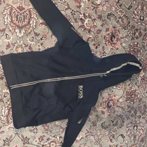 Hugo boss  - Rikigt fet Hugo boss kofta i svart/guld, 6/10 skick i storlek s