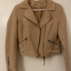 Kort kappa, stl XS/ S - Croppad beige kappa i mocka liknande tyg i fint skick (bortklippt lapp)!  Frakt tillkommer, men kläder som köps kan samfraktas!