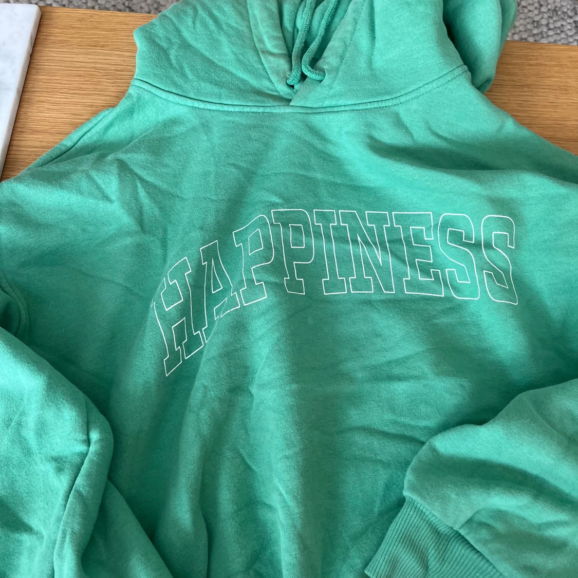 Grön hoodie med texten 'Happiness'