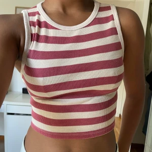 Vit och Röd Randig Topp/Linne - Randig topp från Pull & Bear i storlek M. Säljes då den endast kommit till användning ett fåtal gånger. Modell bär vanligtvis XS/S och är 165 cm.
