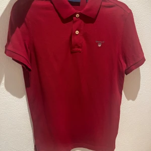 Gant piké röd - En röd och stilren gant piké som ej har använts mycket. Den är i mycket bra skick i storlek xs. Säljer den för 299 kr (nypris: 1100kr).