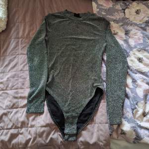 Glittrig långärmad bodysuit ifrån H&M