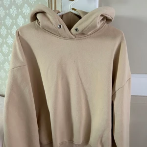 Hoodie - Fin beige hoodie. Finns en lite fläck men som inte syns från håll. Finns ett snöre till också.