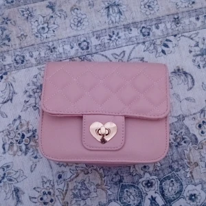 Rosa jättesöt väska - Väskan är från Glitter✨️. Helt ny och aldrig använd. Papper är kvar i väskan📃. Säljer den pga att den är för liten för min mobil. Är i no size. Typ coqette🫶🏾.