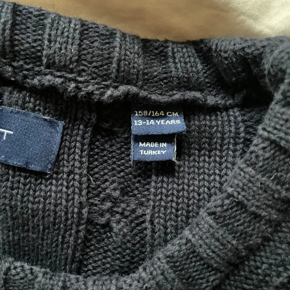 Mörkblå kabelstickad tröja från Gant, i storlek 158/164. . Stickat.