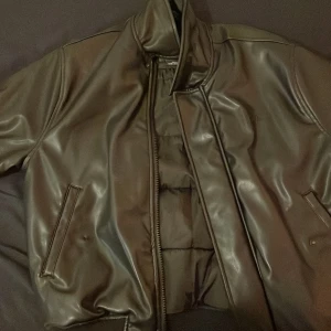 Leather jacka - Skinnjacka från pull and bear, ser väldigt snygg ut och är stilren ett problem är att 3 knappar är trasiga men dragkedjan funkar så man kan fortfarande stänga den. Svart, S