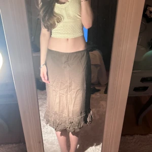 Brun midi skirt - Fin brun kjol med volang nedtill. Mellan lång. Hittar ingen lapp med storleken, men på mig som vanligtvis är S är den lite stor. Jag på bilden är 165 cm.