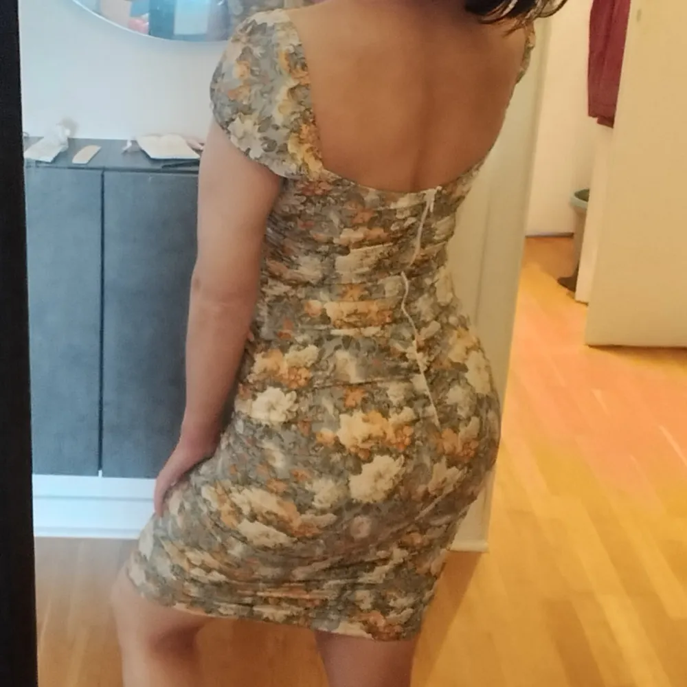 Figurnära och otroligt smickrande klänning i blommigt mönster. Färgerna stämmer bäst in på bild 2, överkroppsbilden. Stretchigt material. Passar nog bäst storlek S.. Mekot.
