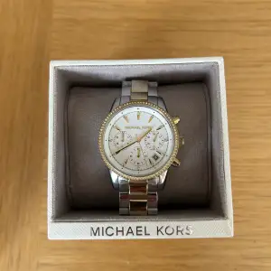 Säljer en Michael Kors klocka i modellen RITZ i silver/guld. Den är i fint skick och har inga repor på uret. Extra länkar och kartong medföljer. Nypris är 2695 kr.