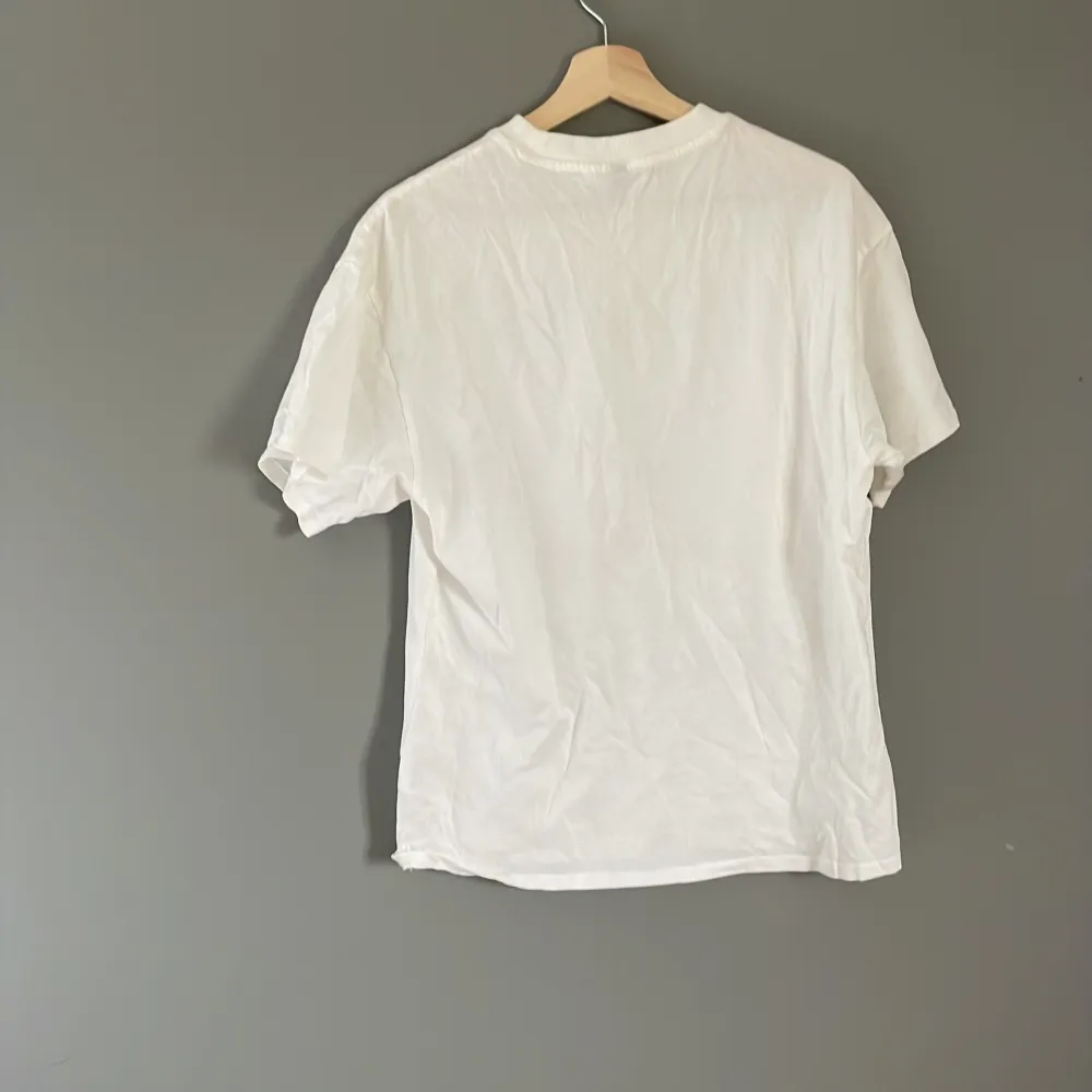 Vit t-shirt i fint skick med tryck från hm i strl xxs passformen är som en vanlig t-shirt men är menad som en overzised . T-shirts.