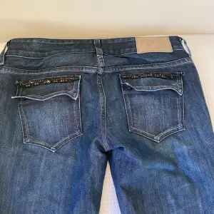Supersnygga low waist jeans som jag säljer för att jag behöver pengarna💕Boot cut såklart med såå snygga svarta nitaar. Innebenslängd: 83 cm.  Full längd: 95 cm. Midjemått: 41 Pris kan diskuteras