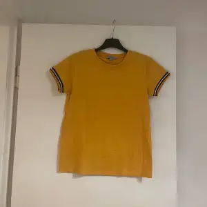 En söt T-shirt som är gullig att ha på sommaren eller när som. Den ser gul ut på bilden men den är lite orange gul. Jätte gullig 