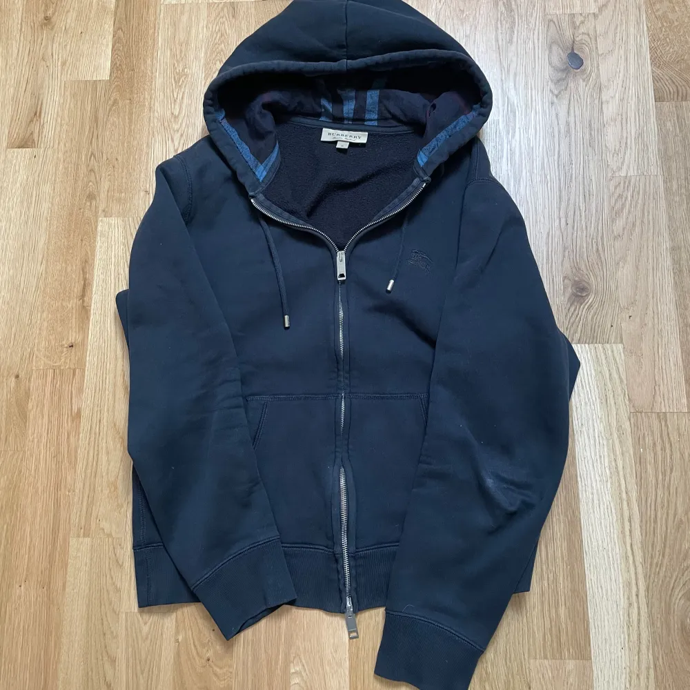 En riktigt snygg zip hoodie från ”Burberry” i väldigt bra skick 9/10. Det finns inga hål eller skavanker på tröjan. Äktehetsbevis från ”Vestiaire” finns (Pris kan diskuteras).. Hoodies.