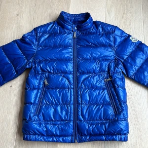 Moncler jacka kid - Bra skick, inga skador. Storlek 140. Mörkblå tunn dunjacka. Nypris ligger runt 5000kr