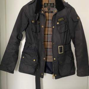 Vår och höstjacka tunt fodrad. Fint använt skick. Slitage runt ärmar, krage och kanter. Du får med en oöppnad burk vax från Barbour. Normal i storlek