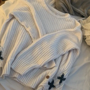 Stickad vit tröja  - En vit stickad tröja med svart snörning nedantill, jätte skön och fin, strlk 170 men passar mig som har M/L på tröjor 