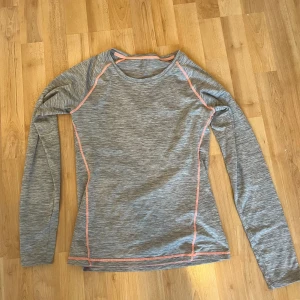 Träningströja  - En fin grå träningströja med ljusrosa sömmar