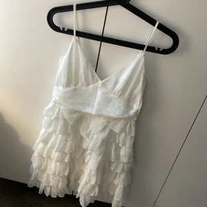 Volang Klänning nakd - Volang klänning från nakd, klänningen har justerbara band och även knytning i ryggen. Strl 36. Använd vid ett tillfälle, inga defekter på klänningen.