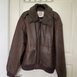 Skinnjacka i äkta läder - Jättefin och skön läderjacka från beyond retro i äkta läder. Nypris 900 kr. Jag har aldrig använt den, prislappen sitter kvar. Storleken är medium. Dragkedjan har en tidigare lagning, men fungerar perfekt! <3