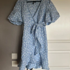 Blå omlottklänning - Jag säljer denna klänning då den inte kommit till användning mer än en gång 🩵