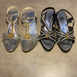 Sandaler- svart&silver - Säljer 2 sommar sandaler med klackar tillsammans. Den silvriga är storlek 35 medan den svarta är 34. Skorna är lite slitna och några skavanker.