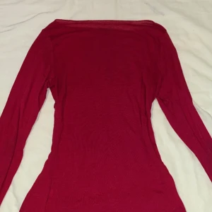 En jättefin röd intimissimi tröja - Den är röd och stretchig. Den är gjord på modelkashmir med boatneck linje. Den är tunn och mjuk och perfekt passform som kramar din kropp. Den är i storlek S men kan även passa M. Den är använd 2-3 gånger. Den är i fint skick och normal i storleken.