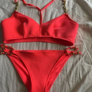 Bikini - En skrik rosa bikini med guldkedjor. Den är helt oanvänd. Storlek 36 på underdelen och sitter som S/XS, överdelen är storlek 40 men sitter som S. Pris kan diskuteras 💞