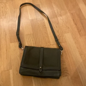 Mörk grön axelväska - Mörkgrön axelväska med guld fästningar och detaljer från Wera 