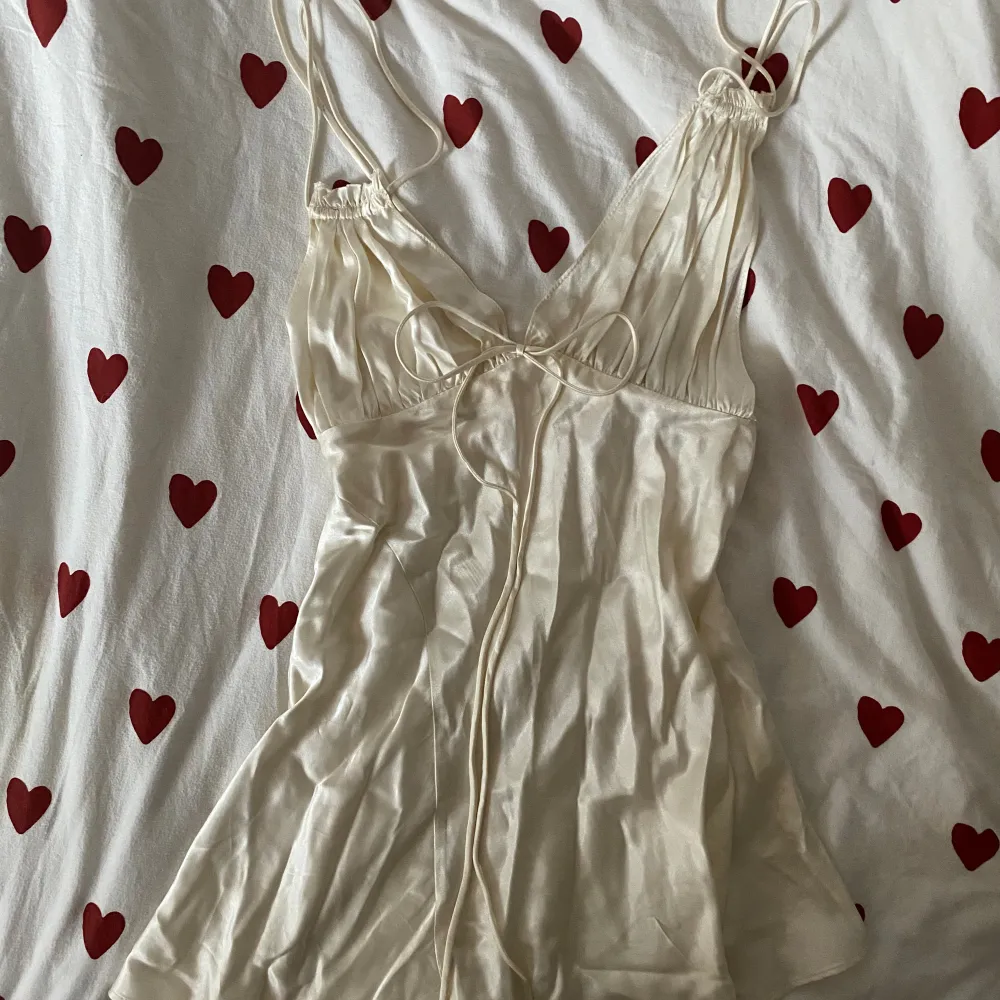 En otroligt snygg miniklänning i créme färgat satin. Den är från ”Zara” i storlek xs. Endast testat och i perfekt skick! . Klänningar.