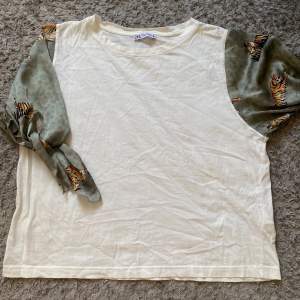 En super fin blus/t-shirt med mönstrade armar i silke material. Knappt använd. Storleken är Xl men den passar som M/S.💕