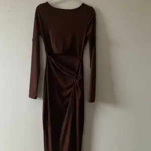 Väldigt unik och fin klänning i brun färg, storlek xs. Knappt använd klänning. Klänningen har en slit på framsidan också. 