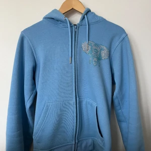Rhinestone Zip Hoodie - Säljer nu min Street Tag Rhinstone hoodie som har blivit för liten. Alla stenar sitter kvar och den är i bra cond. Köpt på deras hemsida för 700:-. Hör av er vid intresse eller andra frågor!