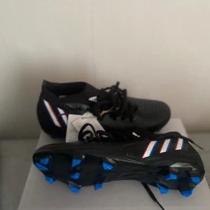 Fotbollsskor  - Storlek: 42 Färg: Svart/blå Passade inte mig och vill sälja dem helt nya ! Pris kan diskuteras också 