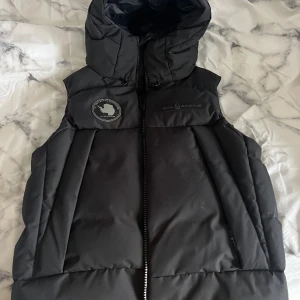 Sail racing väst - En svart väst i dun med huva från Sail racing i mycket bra skick. Använd en handfull gånger.  (Sail racing arctic down vest) 